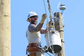 Volunteer Energy Coop lineman reaching for wire