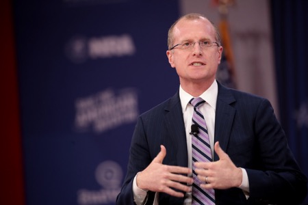 FCC Chair Brendan Carr stands on stage speaking to audience