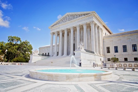 The front of the US Supreme Court building on a clear sunny day