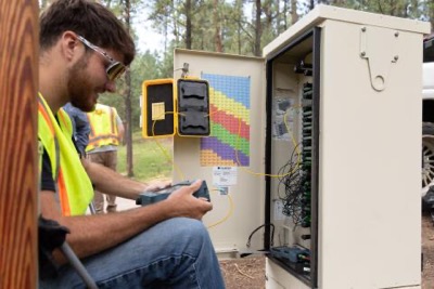 Penasco Valley Telephone Cooperative fiber tech looks inside a roadside fiber cabinet